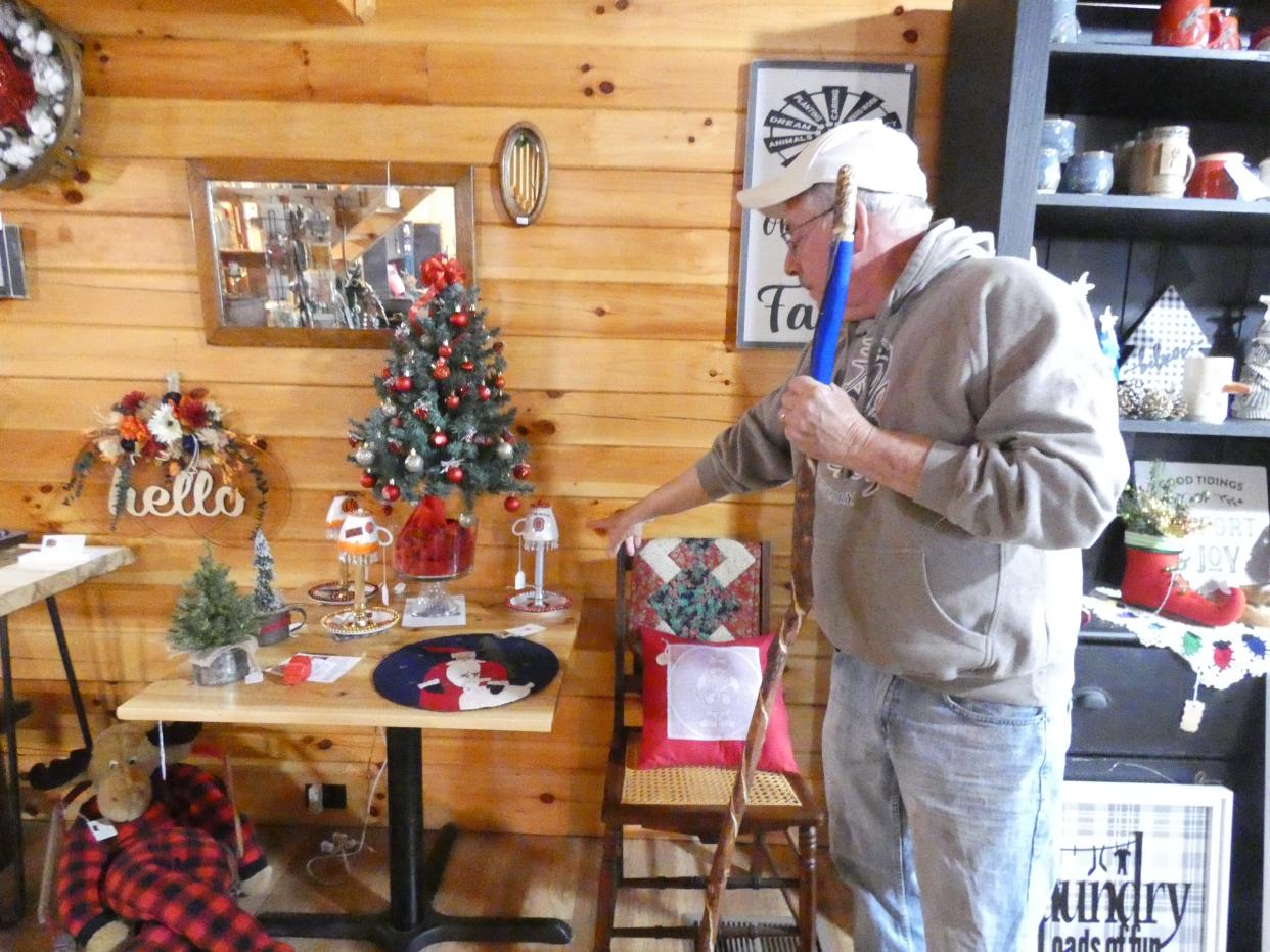 Owner Richard Hancock shows off some of the gift items available at the Cabin at Willow Hollow, 5183 Stetzer Road. The store specializes in hand-crafted arts and crafts, with some selected antiques.