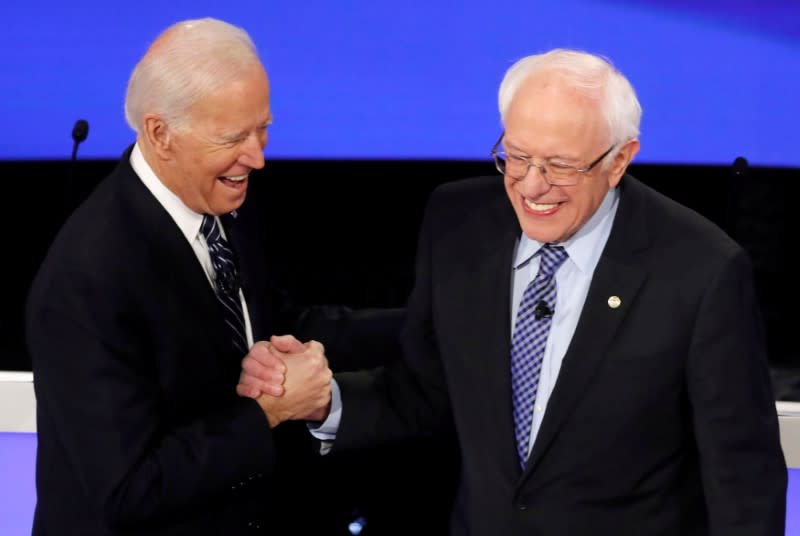 Democratic 2020 U.S. presidential candidates former Vice President Joe Biden greeets Senator Bernie Sanders as they take the stage for the seventh Democratic 2020 presidential debate at Drake University in Des Moines