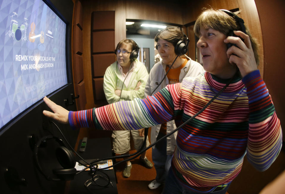 In this April 10, 2014, photo, country music fans Dawn Peach, left, Dede Spinnenweber, center, and Deborah Kuntz record a song at an exhibit at the Country Music Hall of Fame and Museum in Nashville, Tenn. The facility is no longer bursting at the seams, thanks to a $100 million expansion that has more than doubled their space and allowed them to add more interactive and contemporary exhibits. (AP Photo/Mark Humphrey)