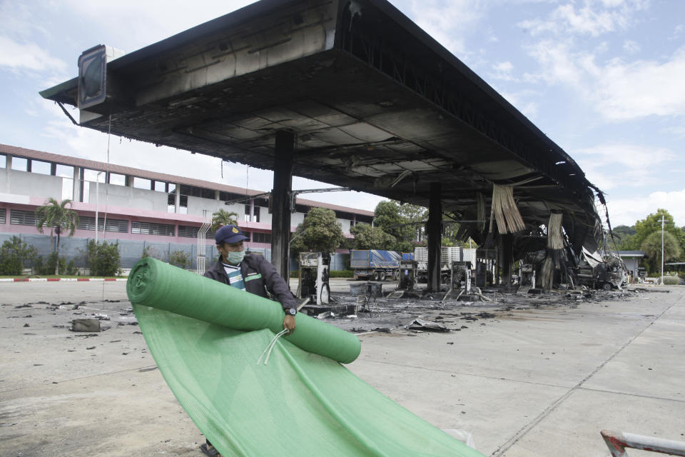 A worker tries to cover the burnt down gas station in Pattani province, southern Thailand, Wednesday, Aug. 17, 2022. A wave of arson and bombing attacks overnight hit Thailand’s southernmost provinces, which for almost two decades have been the scene of an active Muslim separatist insurgency, officials said Wednesday. (AP Photo/Sumeth Panpetch)