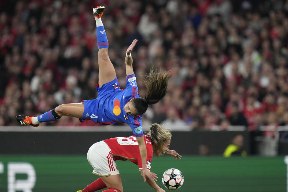 Benfica's Lucia Alves, bottom, challenges for the ball with Lyon's Selma Bacha during the women's Champions League quarterfinals, first leg, soccer match between SL Benfica and Olympique Lyonnais at the Luz Stadium, in Lisbon, Tuesday, March 19, 2024. (AP Photo/Armando Franca)