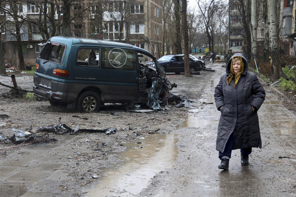 FILE - A local resident walks past a damaged vehicle marked with the letter Z, which has become a symbol of the Russian military, in an area that Russian-backed separatists claim to control in the Ukraine city of Mariupol, Wednesday, April 13, 2022. (AP Photo/Alexei Alexandrov, File)