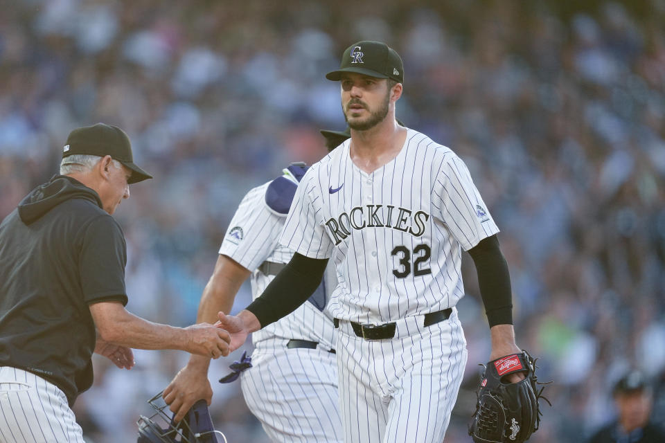 Colorado Rockies manager Bud Black, left, takes the ball from starting pitcher Dakota Hudson as he is pulled from the mound after walking Milwaukee Brewers' Garrett Mitchell to force in a run with the bases loaded in the fifth inning of a baseball gam, Wednesday, July 3, 2024, in Denver. (AP Photo/David Zalubowski)