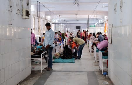 Relatives visit child patients who suffer from acute encephalitis syndrome in a hospital ward in Muzaffarpur