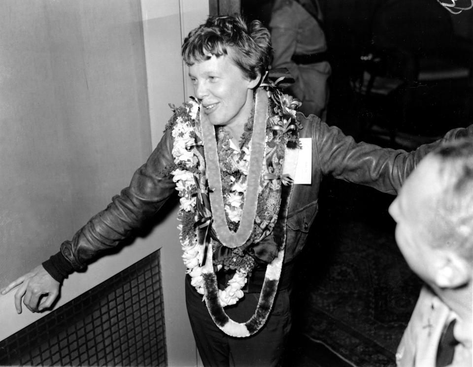 Amelia Earhart wears a string of leis around her neck after landing in Honolulu, Hawaii.