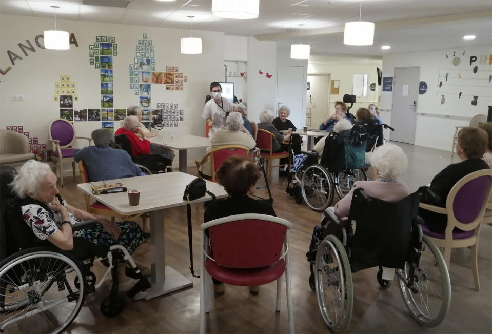 In this photo provided by the Vilanova nursing home, a nurse works with residents inside the Vilanova nursing home on April 22 2020 in Corbas, central France. The nursing staff of a care home in Lyon decided 45 days ago that rather than lock residents in their rooms as the government urged, the staff would lock themselves in the home with residents so as not to deprive the elderly of their freedom. The home has had zero virus cases so far. (Valerie Martin via AP)