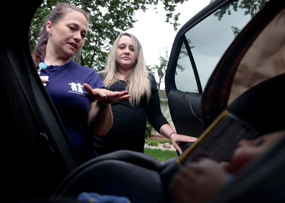 Renee Zarr, a child passenger safety technician and instructor at the Children’s Hospital of Michigan, talks with Jessica Henson, 33, of Warren, about the right way and things to look for in putting an infant into a car seat on July 27, 2023. Henson, who is 32 weeks pregnant,  had Zarr come to her home to learn how it all works.