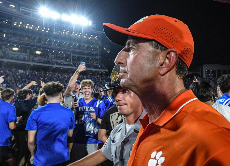 Clemson Tigers head coach Dabo Swinney walks by celebrating Duke Blue Devils fans who stormed the field after a game at Wallace Wade Stadium in Durham, N.C.