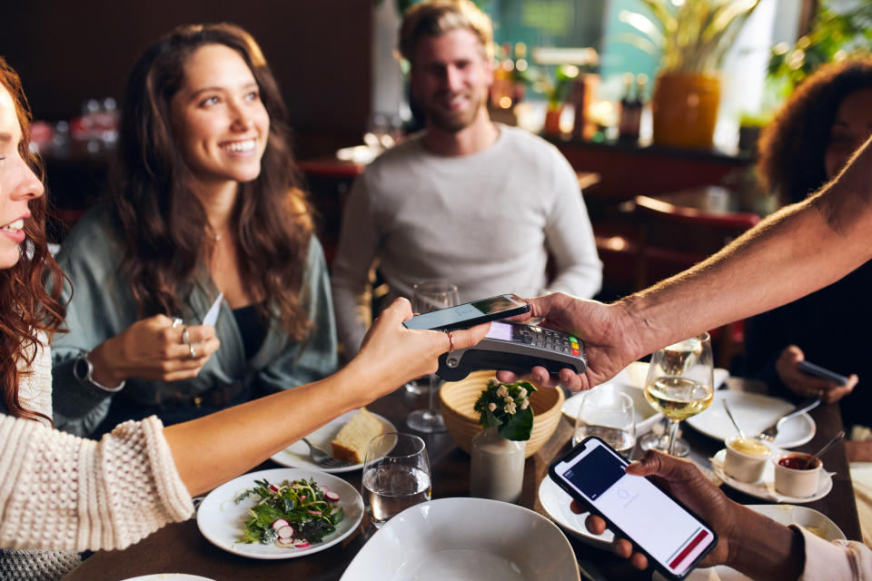 woman picking up the tab for her friends in a restaurant