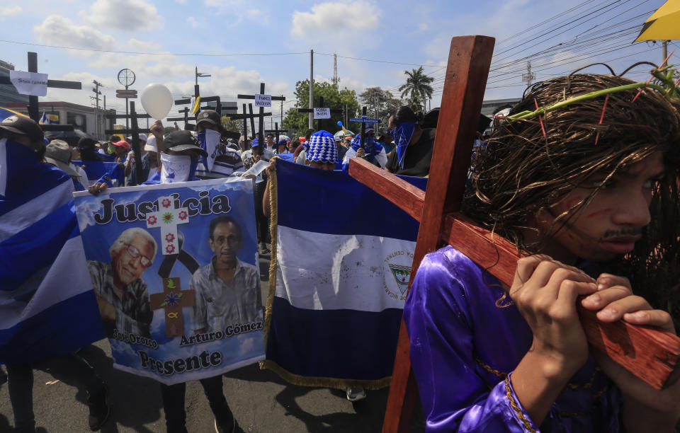 Anti-government protesters join a Stations of the Cross procession on Good Friday, carrying signs demanding the release of political prisoners in Managua, Nicaragua, Friday, April 19, 2019. Good Friday religious processions in Nicaragua’s capital have taken a decidedly political tone as people have seized on a rare opportunity to renew protests against the government of President Daniel Ortega. (AP Photo/Alfredo Zuniga)