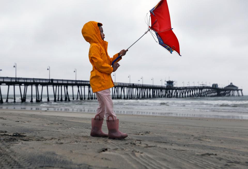 Reagan King battles the wind while out with her parents at Imperial Beach after the eye of Tropical Storm Hilary passed on Sunday, Aug. 20, 2023, in San Diego. The Imperial Beach Pier was closed to the public. (K.C. Alfred/The San Diego Union-Tribune via AP)