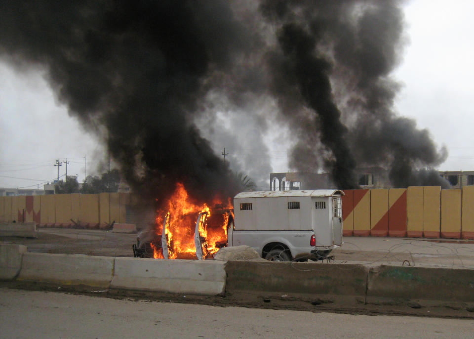 A police truck used to transport prisoners was set afire by al-Qaida fighters after they freed the prisoners, in front of the main provincial government building Wednesday, Jan. 1, 2014. On Wednesday, al-Qaida gunmen fanned out in the streets of towns in the volatile western province of Anbar amid Sunni anger over the arrest of a prominent Sunni lawmaker and the dismantlement of a year-long sit-in the provincial capital Ramadi in recent days. (AP Photo)