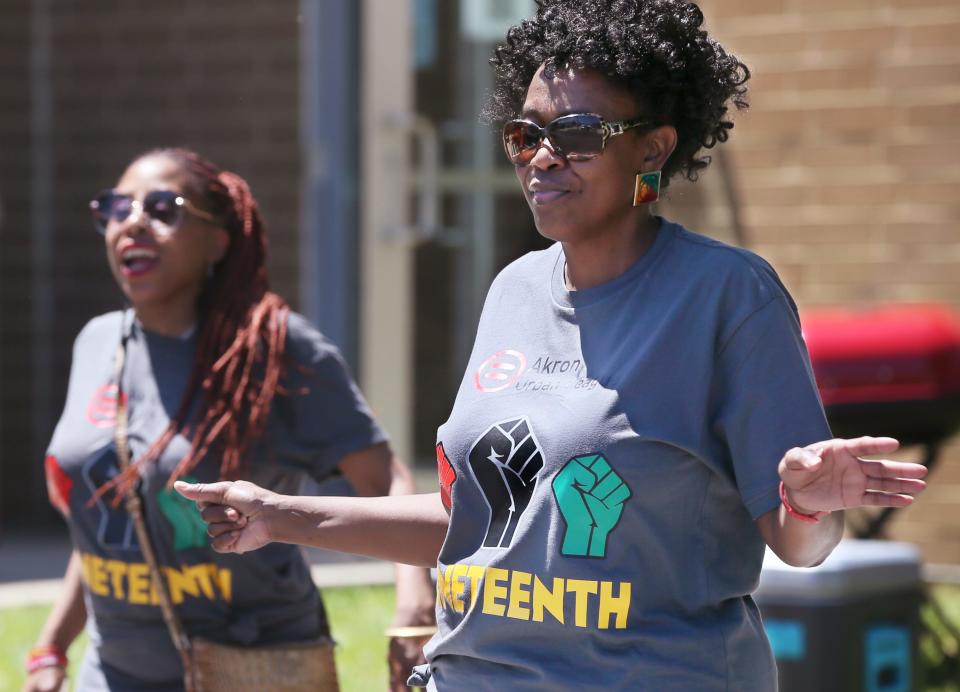 Trisha Dunbar of Akron, right, dances to the music at the Juneteenth event.