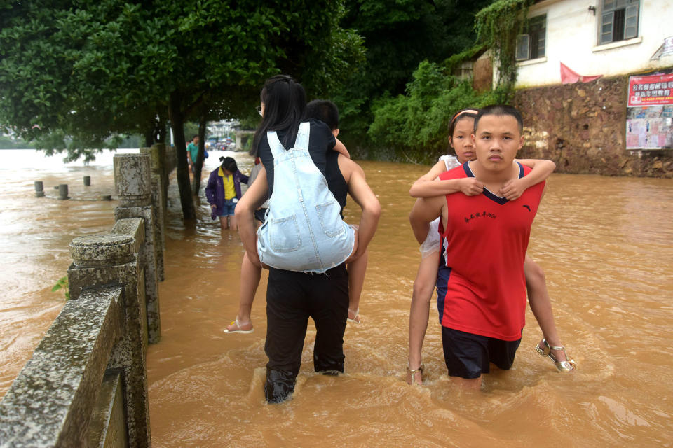 People wade in a flooded street