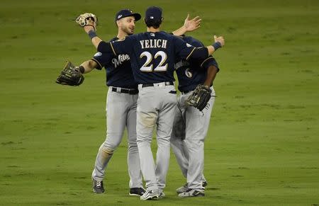 Oct 15, 2018; Los Angeles, CA, USA; Milwaukee Brewers left fielder Ryan Braun (8) and right fielder Christian Yelich (22) and center fielder Lorenzo Cain (6) celebrate after defeating the Los Angeles Dodgers in game three of the 2018 NLCS playoff baseball series at Dodger Stadium. Mandatory Credit: Robert Hanashiro-USA TODAY Sports