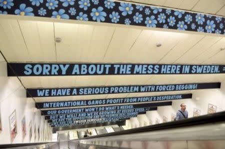 A man ascends an escalator as signs put up by the Sweden Democrats political party are seen at Ostermalmstorg subway station in Stockholm, Sweden, in this August 3, 2015 file photo. REUTERS/Bertil Ericson/TT News Agency/Files