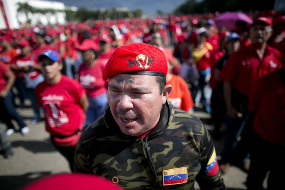 En esta fotografía del 14 de enero de 2017, un simpatizante gubernamental con un logotipo de los ojos del fallecido presidente Hugo Chávez dibujado en la frente participa durante un desfile cívico militar llamado Zamora 200, en Caracas, Venezuela. El gobierno de Venezuela rechazó la decisión del gobierno de Barack Obama de ampliar por un segundo año una orden ejecutiva que declara la emergencia nacional en esa nación sudamericana asolada por la crisis. (AP Foto/Ariana Cubillos)