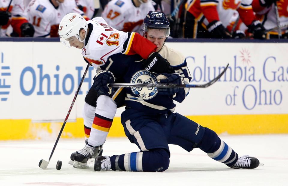 Calgary Flames' Johnny Gaudreau, left, carries the puck up ice as Columbus Blue Jackets' Ryan Murray defends during the third period of an NHL hockey game Thursday, Jan. 21, 2016, in Columbus, Ohio. The Flames defeated the Blue Jackets 4-2. (AP Photo/Jay LaPrete)