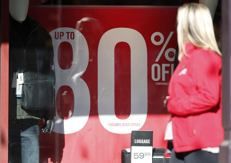 A placard advertises the discount available in a shop as last-minute shoppers finish up their Christmas gift lists at the Outlet Malls in Castle Rock Monday, Dec. 24, 2018, in Castle Rock, Colo. Retailers were offering ample discounts plus even more price cuts to those shoppers who ventured out with the holiday looming. (AP Photo/David Zalubowski)