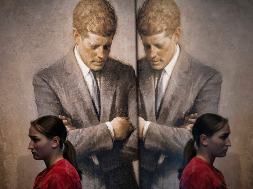 A student walks past the portrait of John F Kenndy that hangs in the White House in 2013 (Brendan Smialowski/AFP via Getty Images)