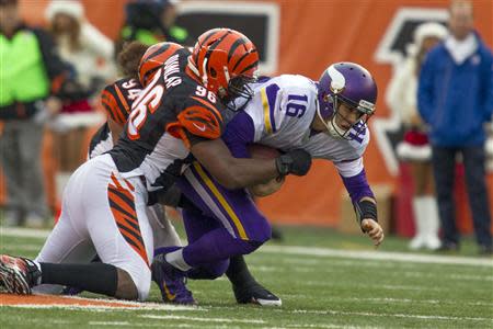 Dec 22, 2013; Cincinnati, OH, USA; Minnesota Vikings quarterback Matt Cassel (16) is sacked by Cincinnati Bengals defensive end Carlos Dunlap (96) and defensive tackle Domata Peko (94) in the third quarter of the game at Paul Brown Stadium. Cincinnati Bengals beat the Minnesota Vikings by the score of 42-14. Mandatory Credit: Trevor Ruszkowksi-USA TODAY Sports