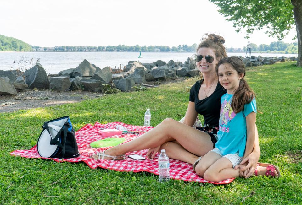 Jenai, left, and Amelia Aybar, 8, from Levittown, have a picnic along the Delaware River at the Bristol Warf in Bristol Borough as the region deals with the latest heatwave on Monday, June 17, 2024.