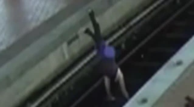 The woman does a handstand on the train tracks. Photo: YouTube