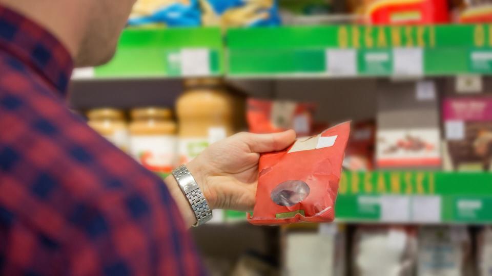 Man choosing snacks in supermarket.