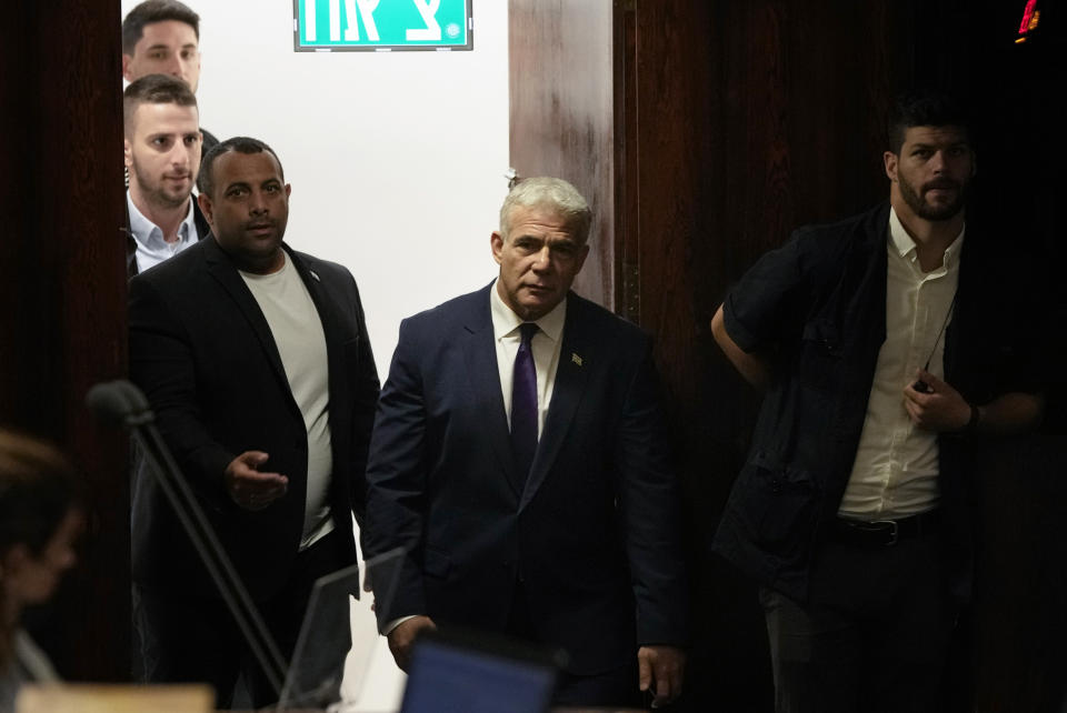 Israeli Foreign Minister Yair Lapid, center, arrives for a preliminary vote on a bill to dissolve parliament, at the Knesset, Israel's parliament, in Jerusalem, Wednesday, June 22, 2022. Israeli lawmakers voted in favor of dissolving parliament in a preliminary vote, setting the wheels in motion to send the country to its fifth national election in just over three years. (AP Photo/Maya Alleruzzo)