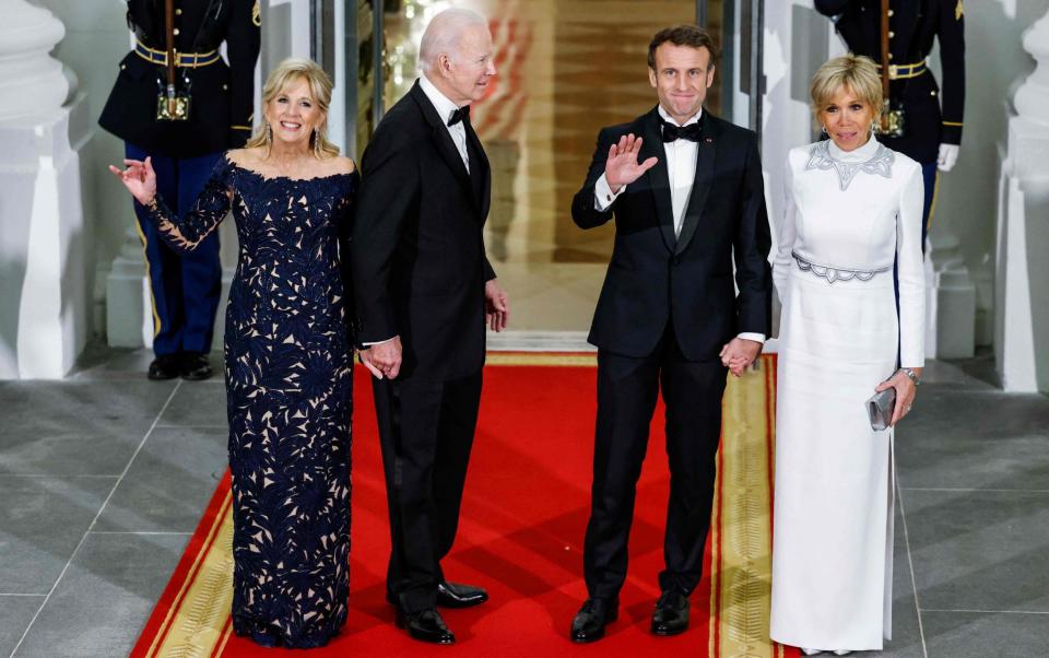 US president Joe Biden and first lady Jill Biden greet French president Emmanuel Macron and his wife, Brigitte Macron, as they arrive for a state dinner - AFP