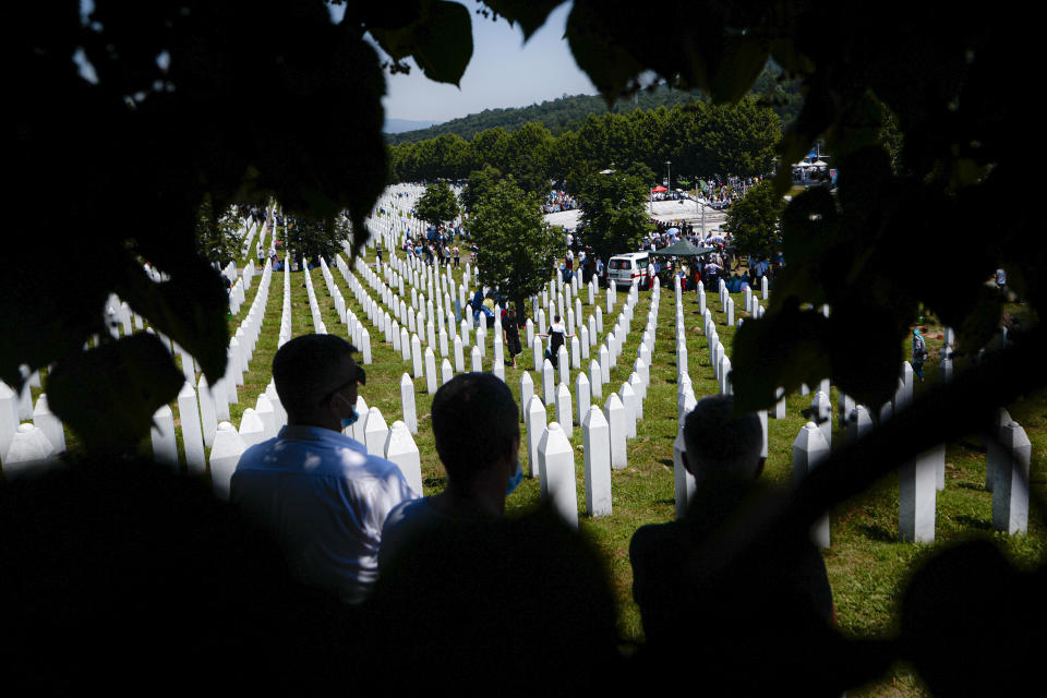 Bosnians attend the funerals of nine massacre victims in Potocari, near Srebrenica, Bosnia, Saturday, July 11, 2020. Mourners converged on the eastern Bosnian town of Srebrenica for the 25th anniversary of the country's worst carnage during the 1992-95 war and the only crime in Europe since World War II that has been declared a genocide. (AP Photo/Kemal Softic)
