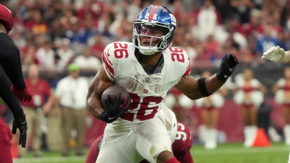 New York Giants running back Saquon Barkley (26) runs the ball against the Arizona Cardinals at State Farm Stadium in Glendale on Sept. 17, 2023.