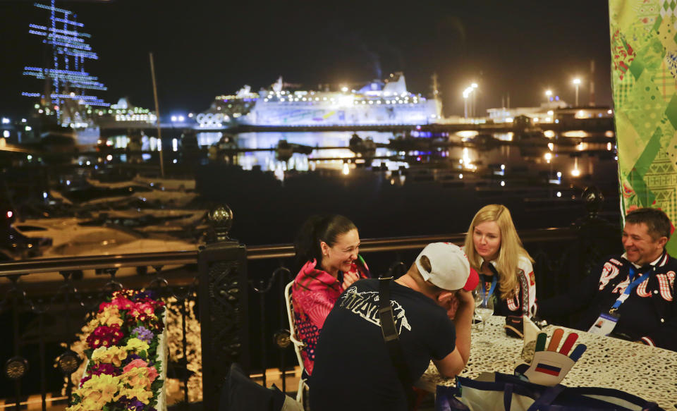 Patrons sit out at a restaurant along the seaport on the Black Sea, Saturday, Feb. 15, 2014, in central Sochi, Russia, home of the 2014 Winter Olympics. (AP Photo/David Goldman)