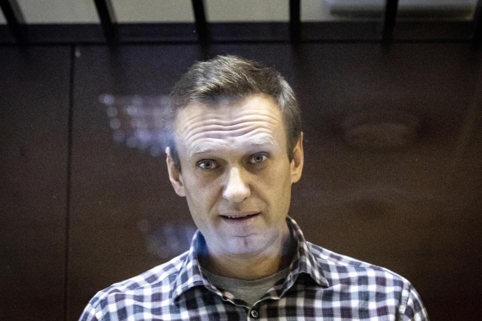 FILE - Russian opposition leader Alexei Navalny looks at photographers from behind a glass cage in the Babuskinsky District Court in Moscow, Russia, on Feb. 20, 2021. Navalny due to hear the verdict Friday Aug. 4, 2023 in his latest trial on extremism charges. The prosecution has demanded a 20-year prison sentence, and the politician himself said he expects a lengthy prison term. (AP Photo/Alexander Zemlianichenko, File)