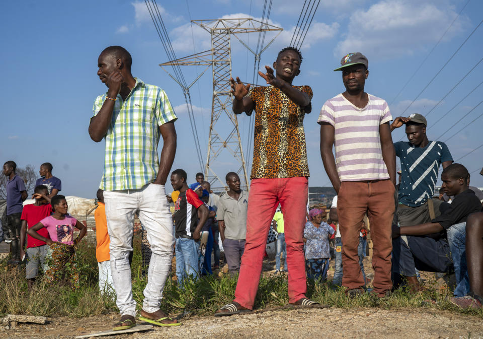 Residents of the Sjwetla informal settlement gather to protest the lack of food, on the outskirts of the Alexandra township in Johannesburg, Monday, April 20, 2020. Many have lost their income as South Africa is under a strict five-week lockdown in a effort to fight the coronavirus pandemic. (AP Photo/Jerome Delay)