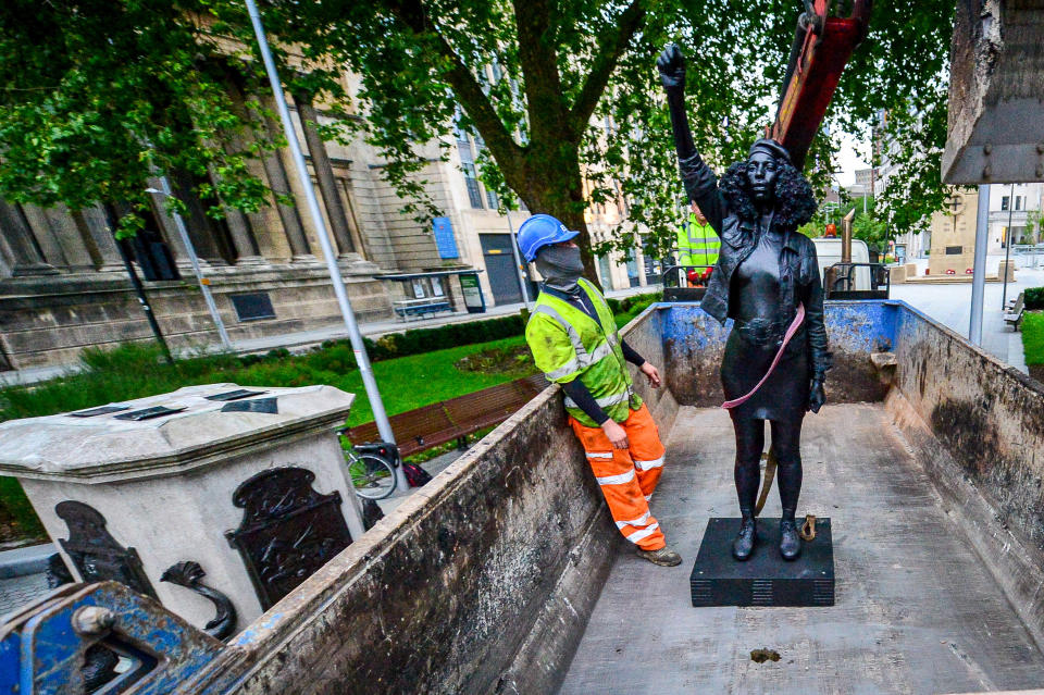 A Surge of Power (Jen Reid) 2020, by prominent British sculptor Marc Quinn, which has been installed in Bristol on the site of the fallen statue of the slave trader Edward Colston, is removed from the plinth and loaded into a recycling and skip hire lorry by contractors.