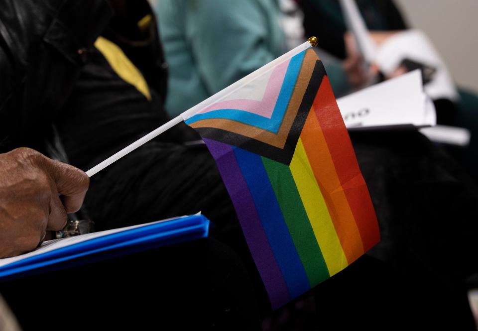 People hold pride flags during a news conference on Feb. 13, 2024.