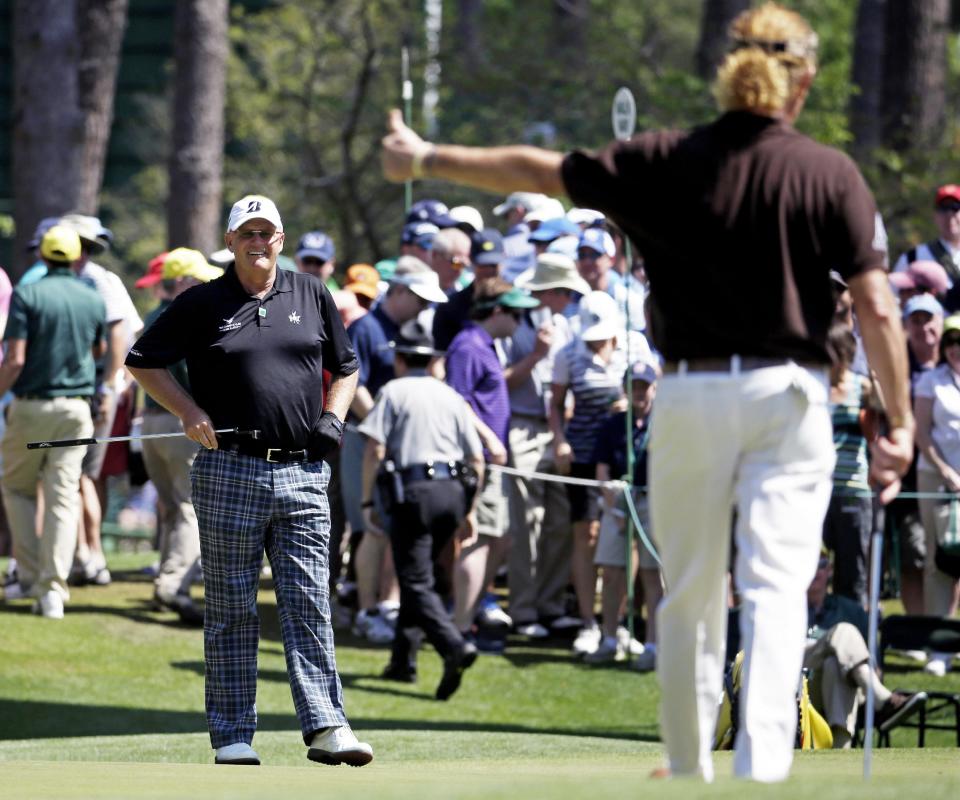 Miguel Angel Jimenez, right, of Spain, gives Sandy Lyle, of Scotland, a thumb's up after Lyle's birdie on the sixth green during the third round of the Masters golf tournament Saturday, April 12, 2014, in Augusta, Ga. (AP Photo/Darron Cummings)