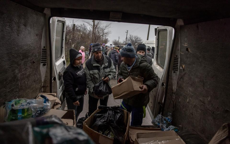 Local people receive humanitarian aid from volunteers at a frontline village in the Beryslav district, in Kherson region - Roman Pilipey/EPA