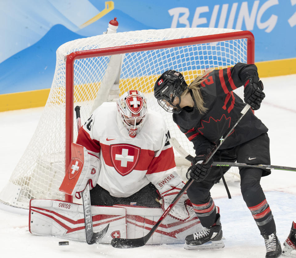 Canada forward Natalie Spooner (24) is stopped by Switzerland goalkeeper Andrea Braendli (20) during the first period of a women's hockey game Thursday, Feb. 3, 2022, at the Winter Olympics in Beijing. (Ryan Remiorz/The Canadian Press via AP)