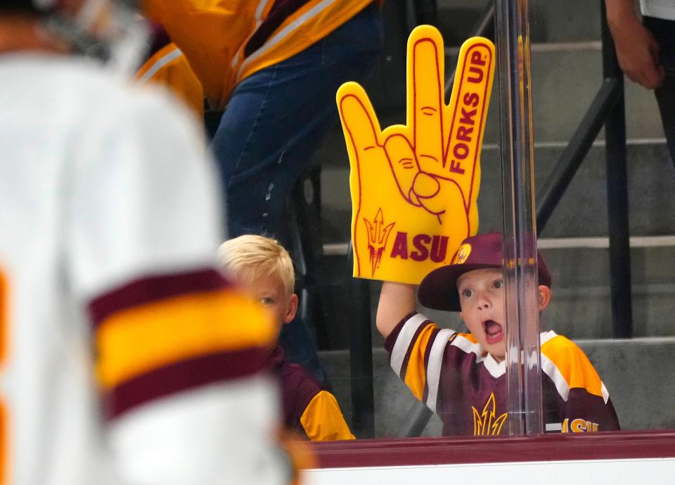 October 14, 2022; Tempe, Ariz; USA; A young ASU fan cheers on the team during a game against Colgate at Mullett Arena. Mandatory Credit: Patrick Breen-Arizona Republic