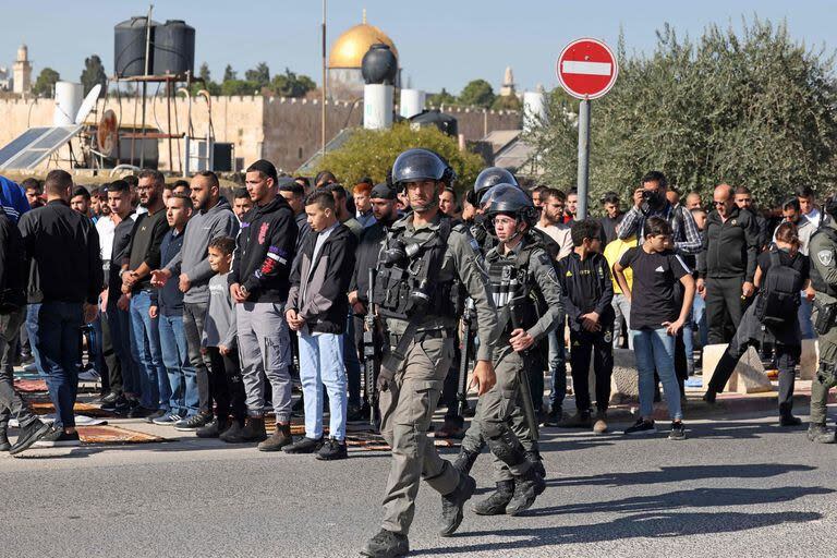 Fuerzas israelíes patrullan la zona mientras musulmanes palestinos realizan la oración del mediodía del viernes en la calle en el barrio de Ras al-Amud, en Jerusalén oriental, el 1 de diciembre de 2023.