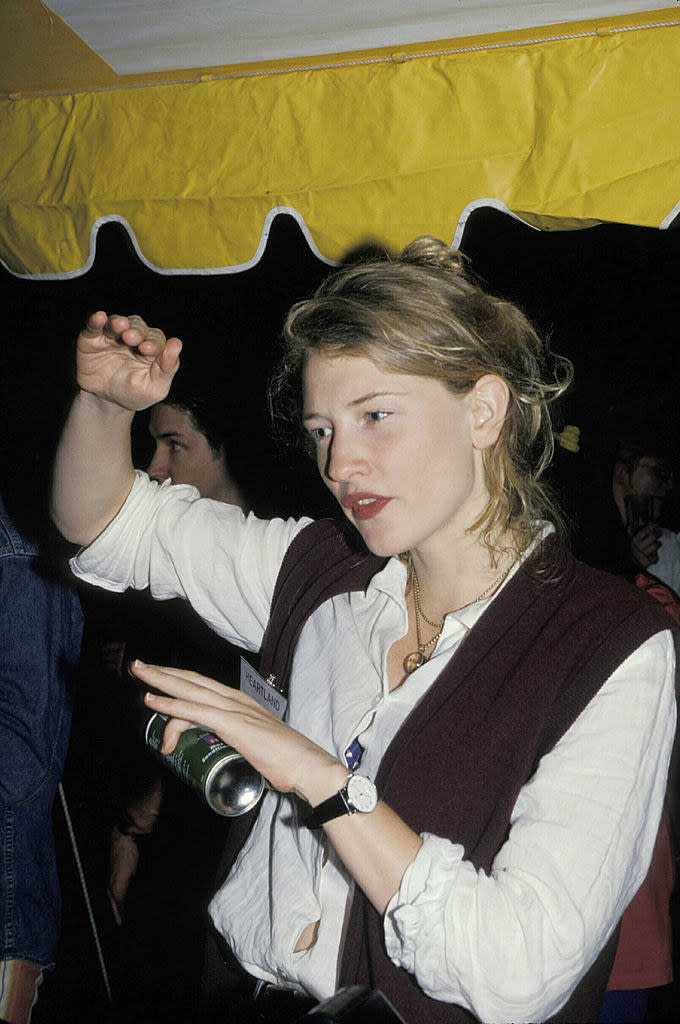 Blanchett gesturing as she wearing a long-sleeved blouse and vest