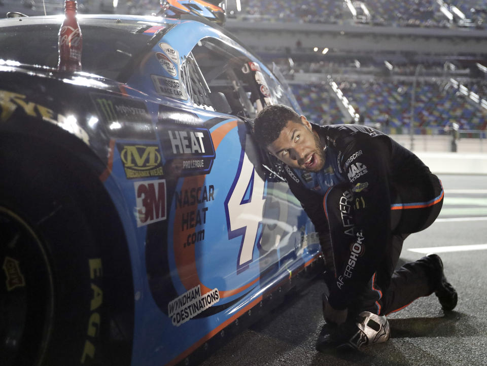 Darrell Wallace Jr. adjusts his driving shoes before getting into his car before the first of two qualifying auto races for the NASCAR Daytona 500 at Daytona International Speedway, Thursday, Feb. 14, 2019, in Daytona Beach, Fla. (AP Photo/John Raoux)