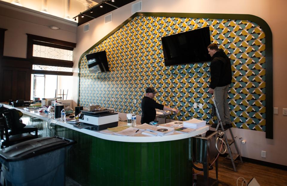 Workers install televisions in the newly renovated bar near the front entrance of the future home of Bobcat Bonnie'sTuesday, Jan. 16, 2024.