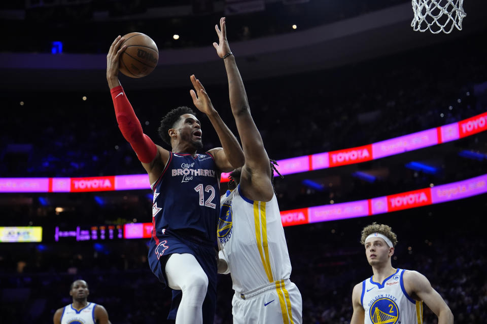 Philadelphia 76ers' Tobias Harris (12) goes up for a shot against Golden State Warriors' Kevon Looney (5) during the first half of an NBA basketball game, Wednesday, Feb. 7, 2024, in Philadelphia. (AP Photo/Matt Slocum)