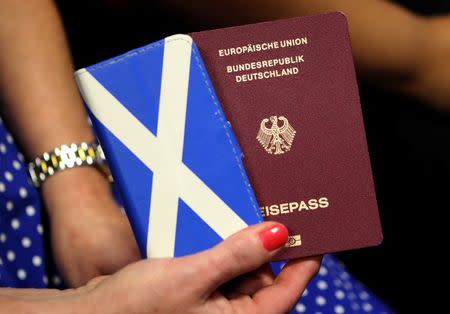 A women holds her phone and EU passport at the public Question and Answer event with EU nationals living in Scotland, at the Corn Exchange, Edinburgh, Scotland August 17, 2016. REUTERS/Russell Cheyne