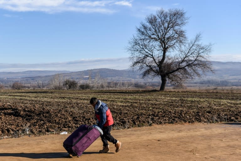 A boy pushes a suitcase as he walks with other migrants and refugees after crossing the Macedonian border into Serbia near the village of Miratovac on January 8, 2016