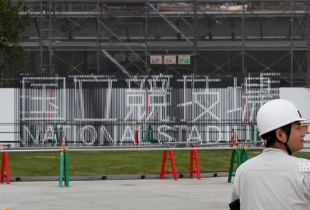 A worker is seen at the construction site of the New National Stadium, the main stadium of Tokyo 2020 Olympics and Paralympics, during a media opportunity in Tokyo