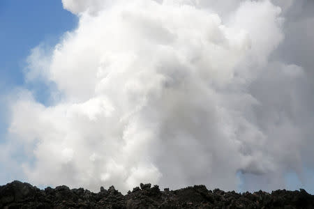 Steam rises as a lava flow enters the Pacific Ocean southeast of Pahoa during ongoing eruptions of the Kilauea Volcano in Hawaii, U.S., May 20, 2018. REUTERS/Terray Sylvester